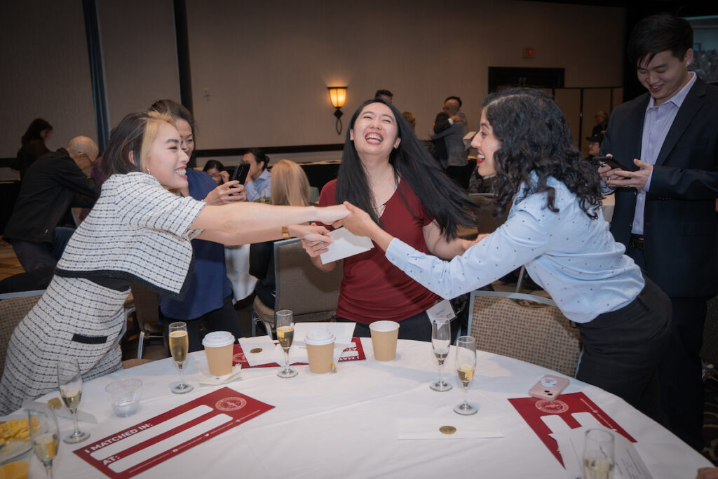 A group of COMP Students laughing at a table.