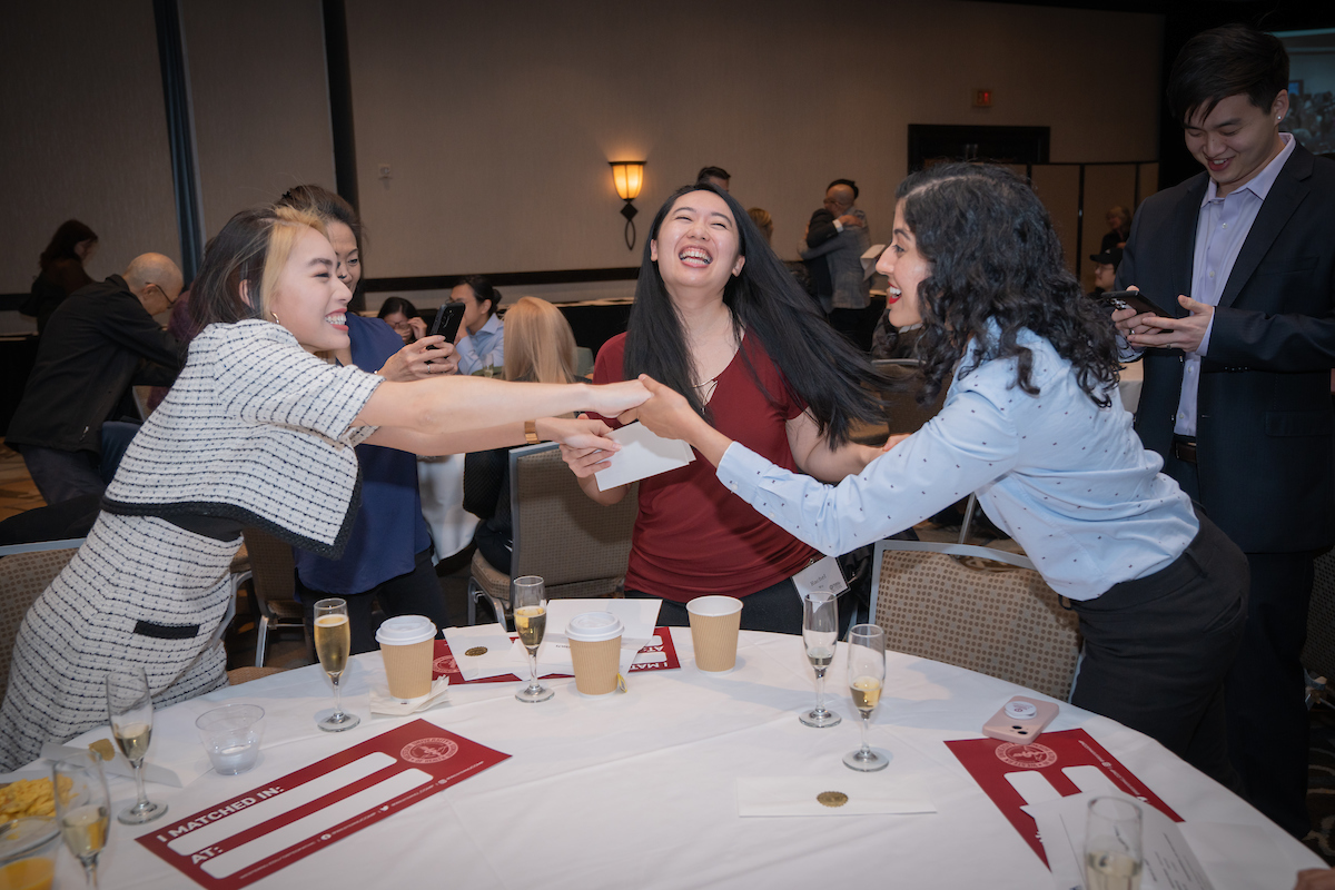 A group of COMP Students laughing at a table.