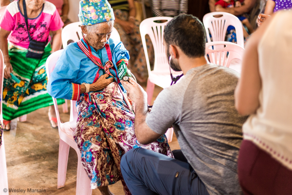 A group of people sitting around a woman in a traditional dress.