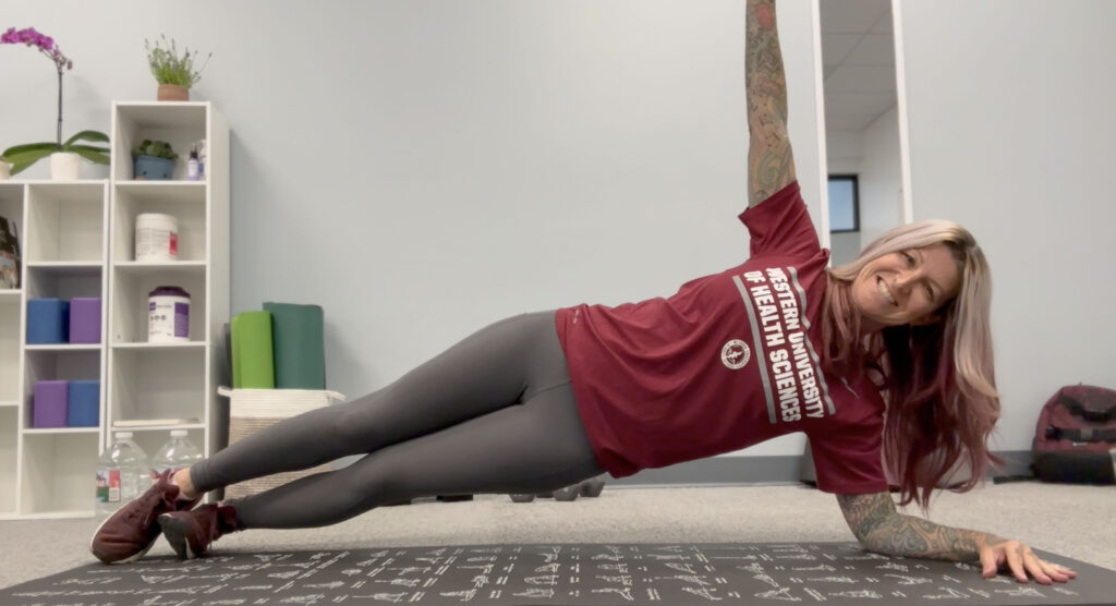 A woman doing a plank exercise in an office.