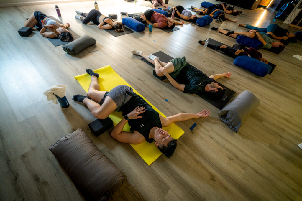 A group of people laying on mats in a room.